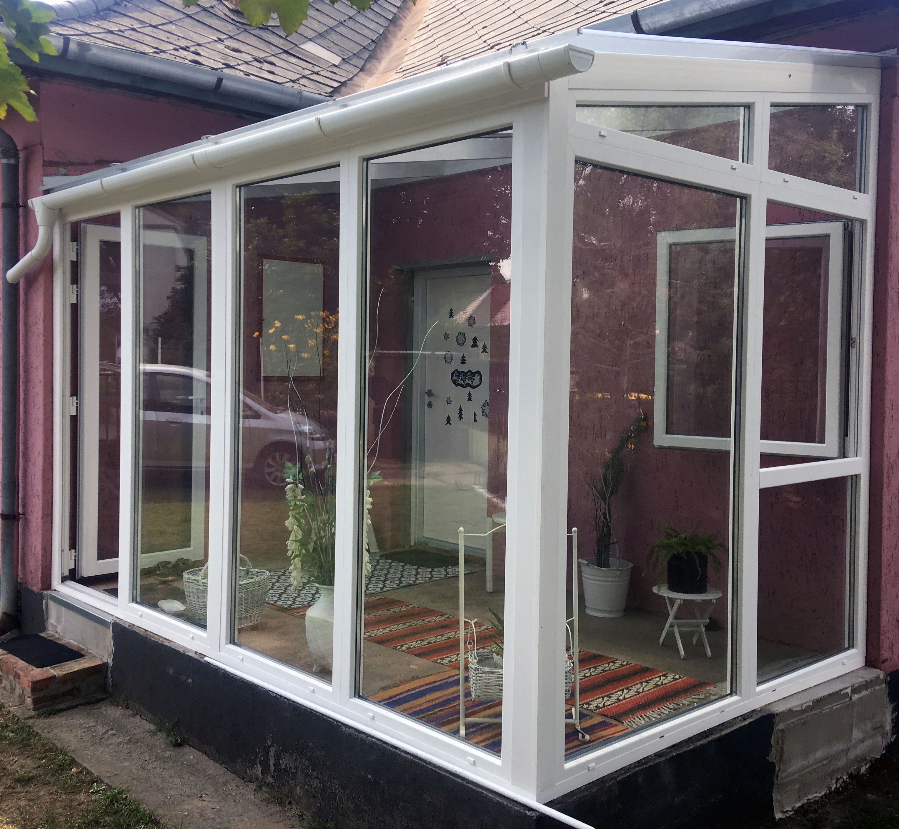 Fehér lakótélikert nagy üvegfelülettel csakádi házhoz kapcsolva