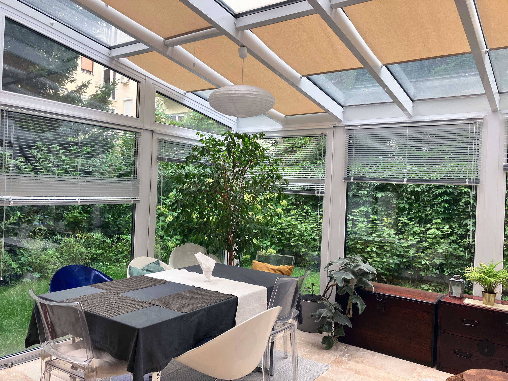 Teraszbeépítés belső tér növényekkel és fehér ülőgarnítúrával