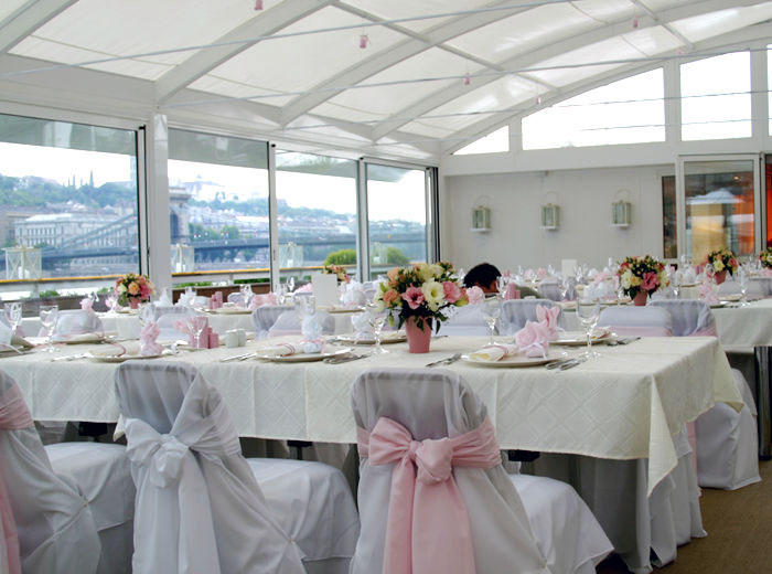 Modern fehér télikert belső tere hatalmas üvegfelülettel nagy asztallal