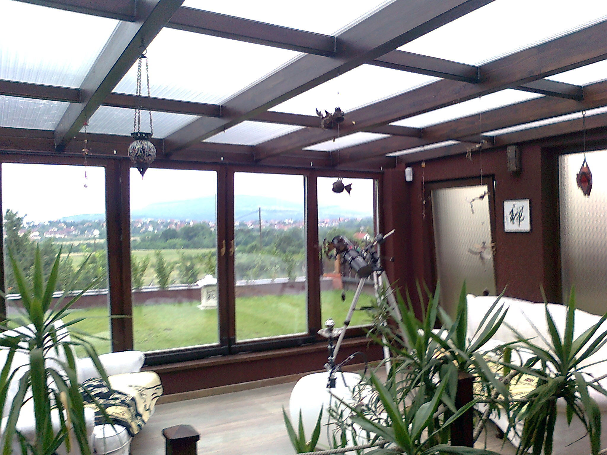 Fa hatású barna lakótélikert belső tere növényekkel és ülőgarnitúrával