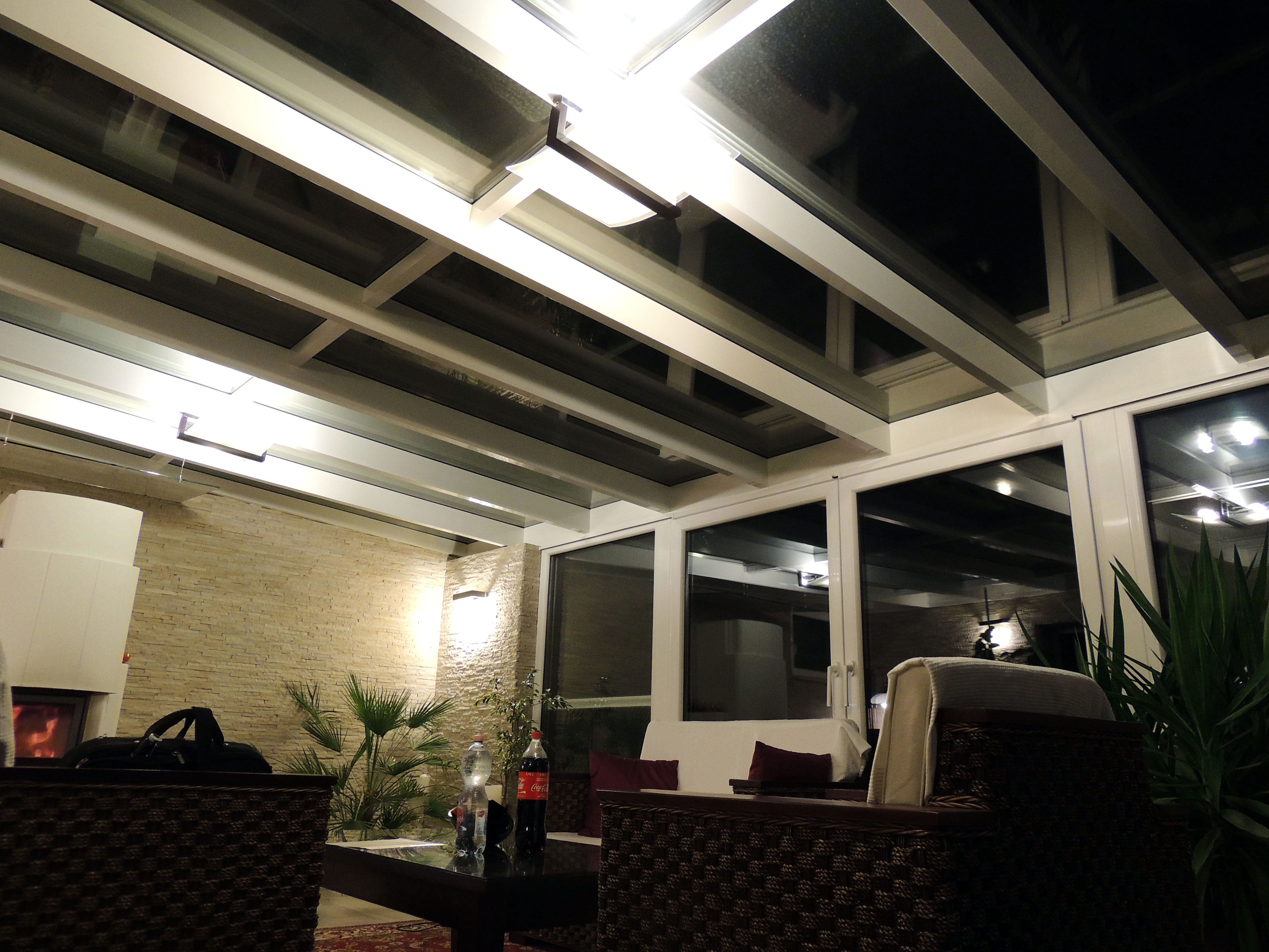 Lakótélikert belső tere este egy kanapéval és nagy üvegfelülettel