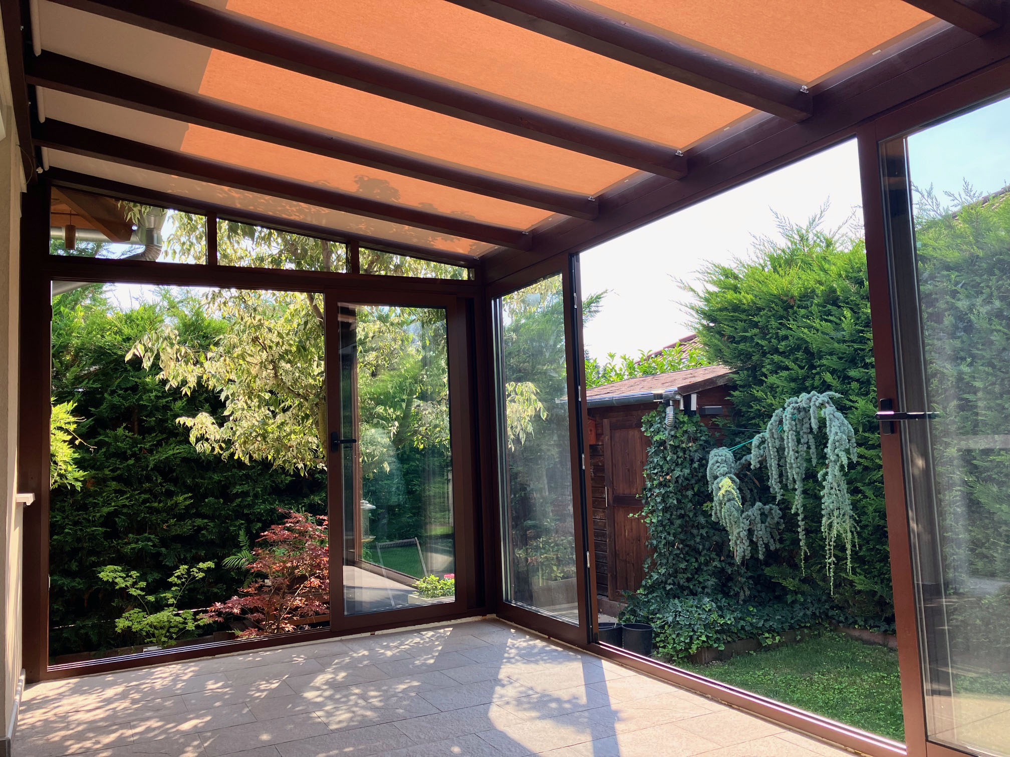 Fa hatású barna télikert nagy üvegfelülettel tolóajtóval