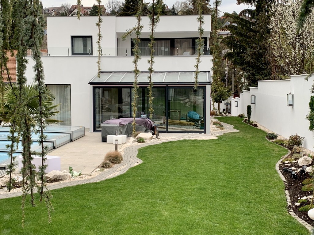 Modern szürke télikert családi házhoz kapcsolva tolóajtóval