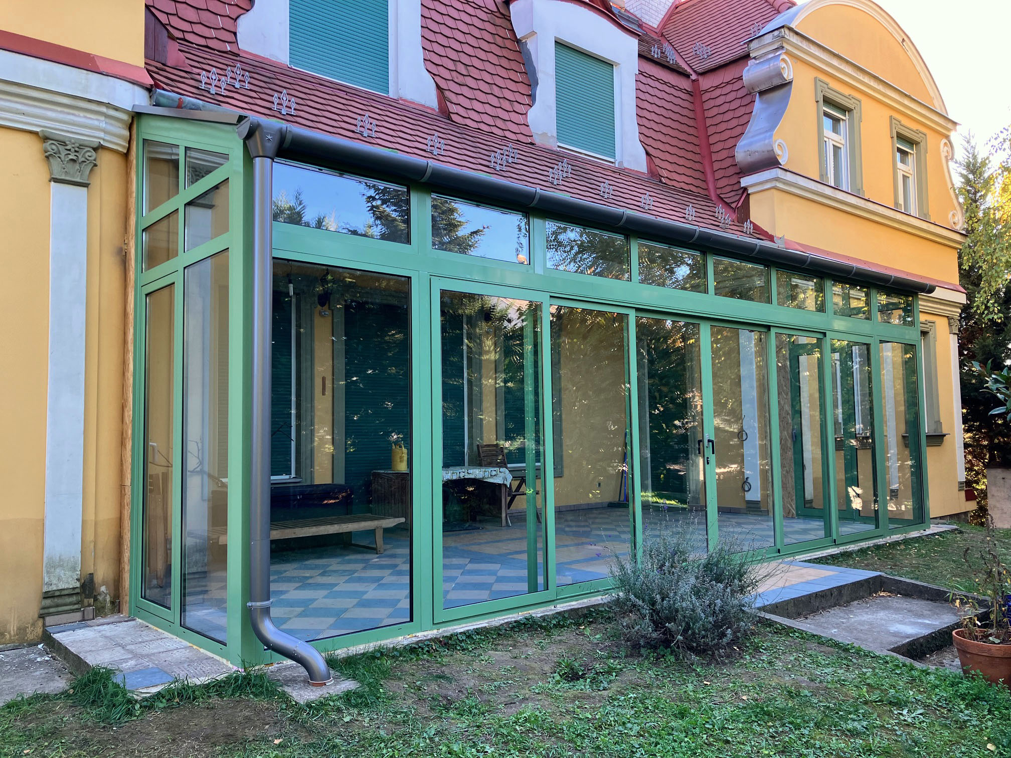 Zöld fahatású télikert egy családi házhoz kapcsolva