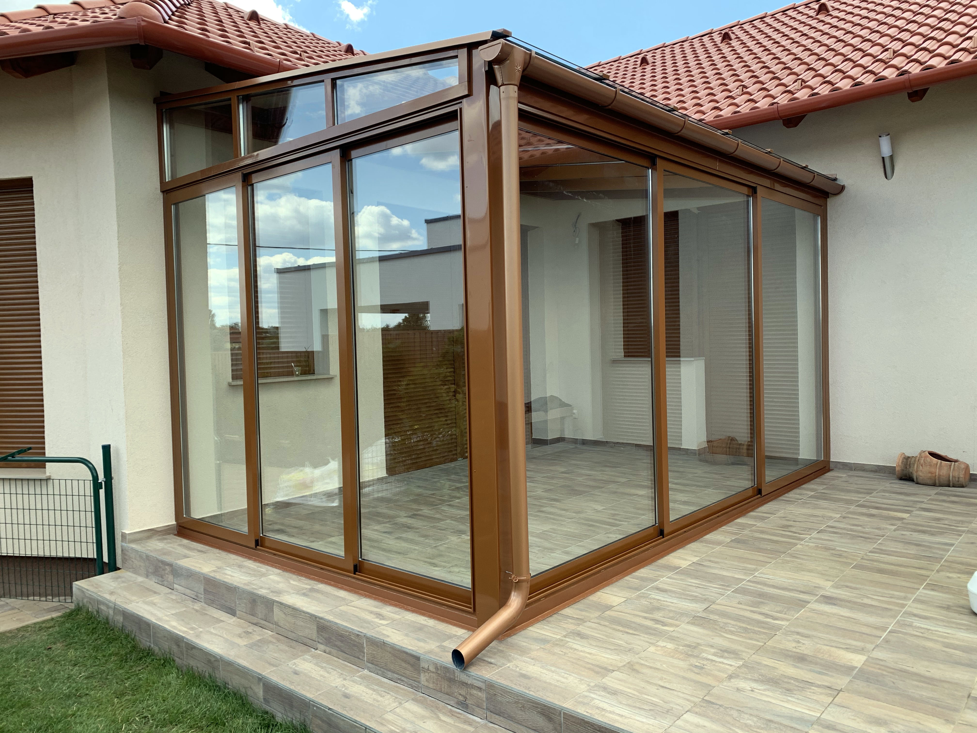 Fa hatású letisztult télikert nagy üvegfelülettel