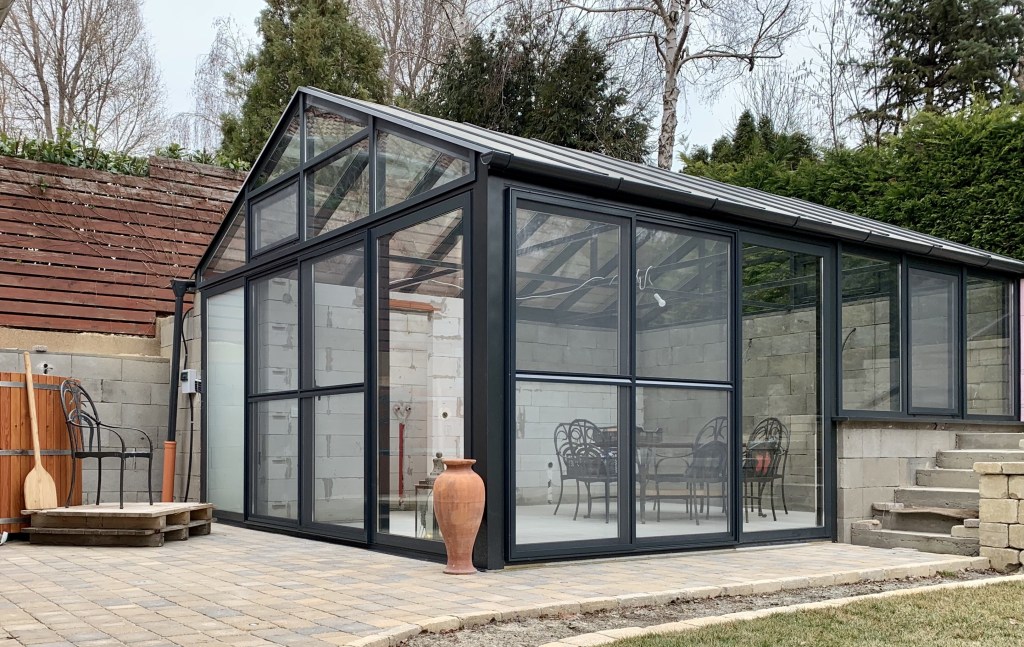 Külön álló télikert hatlmas üvegfelülettel belül letisztult berendezés